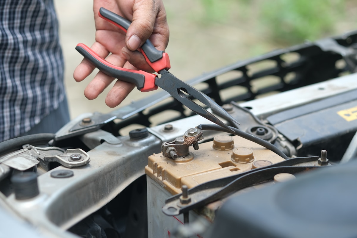 Professional mechanic working on car engine repair in workshop